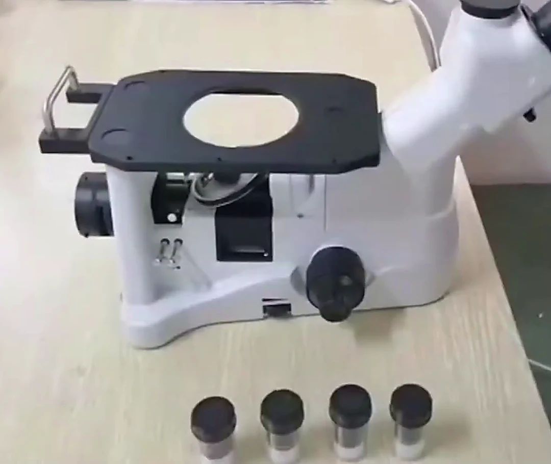 G-800E trinocular metallurgical microscope on a bench with its four objectives placed in front